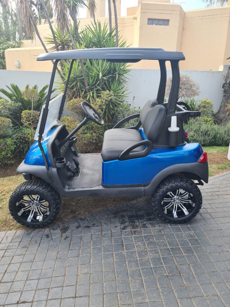 Image of a blue golf cart with custom mag wheels.